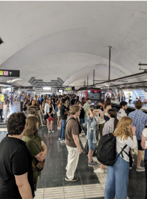 Author’s Photo: Frequent service makes subway systems like the one in Barcelona popular at all hours of the day. Shown are people waiting for a train at the Espanya station at 11 p.m. on a Friday night, June 2024.